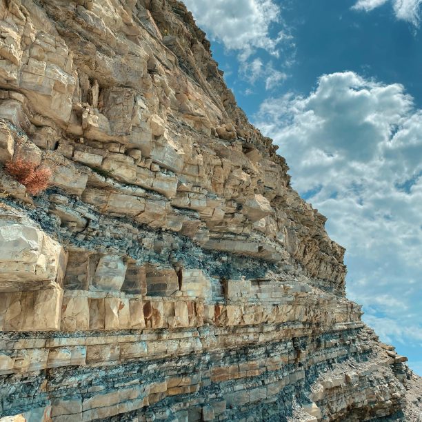 Stunning view of layered rock formations with a dramatic cloudy sky backdrop.